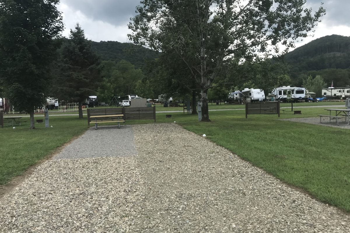 Gravel camping pad, picnic tables, RV sites and wooded hills at Allegheny River Campground in 2019