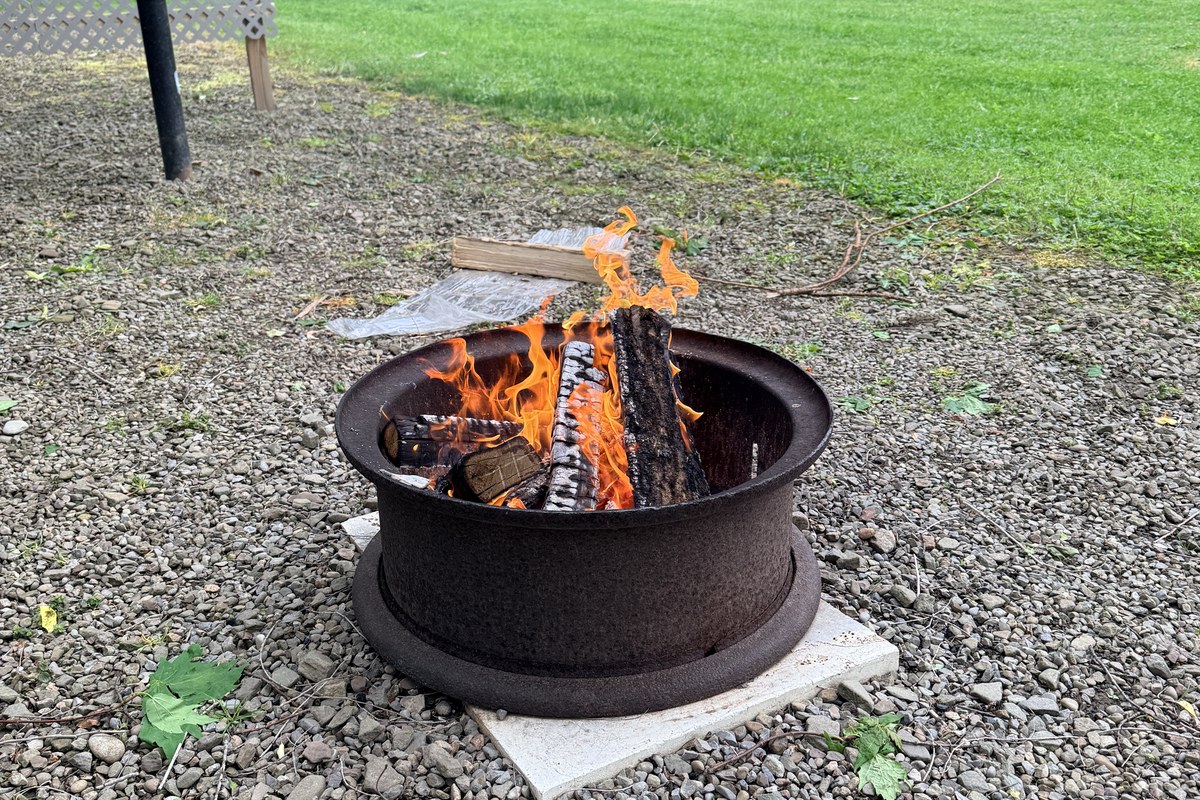 A campfire burning in the fire ring beside our cabin during the 2026 stay